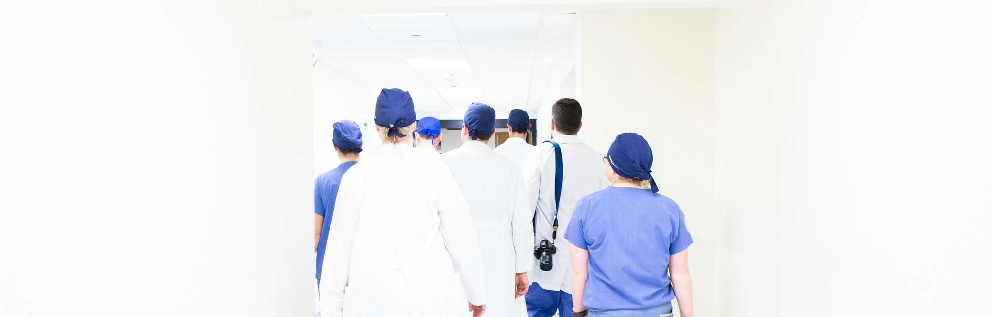 Equipo clínico recorriendo el pasillo de un hospital